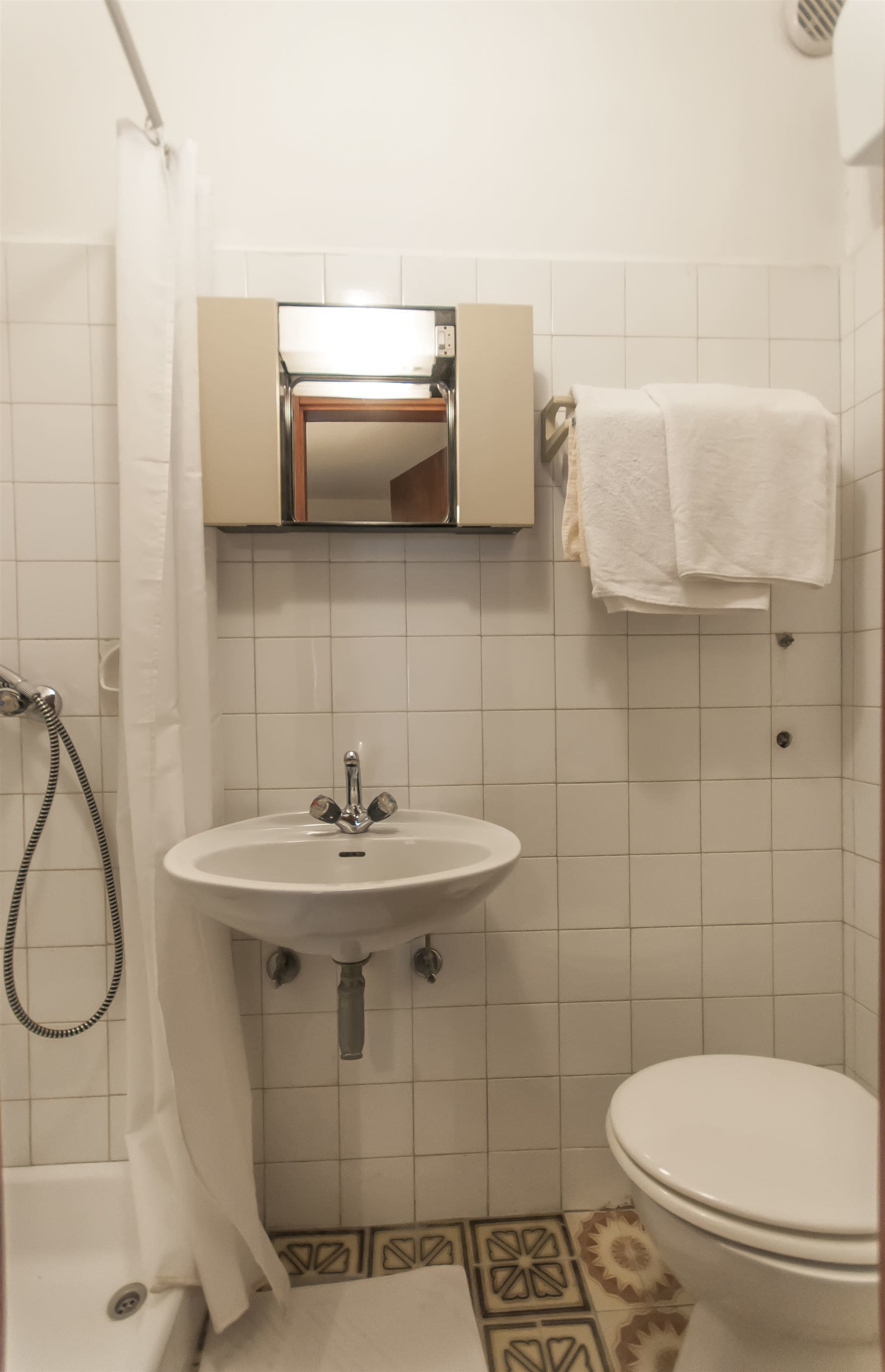 A bathroom with a sink, toilet, and shower.