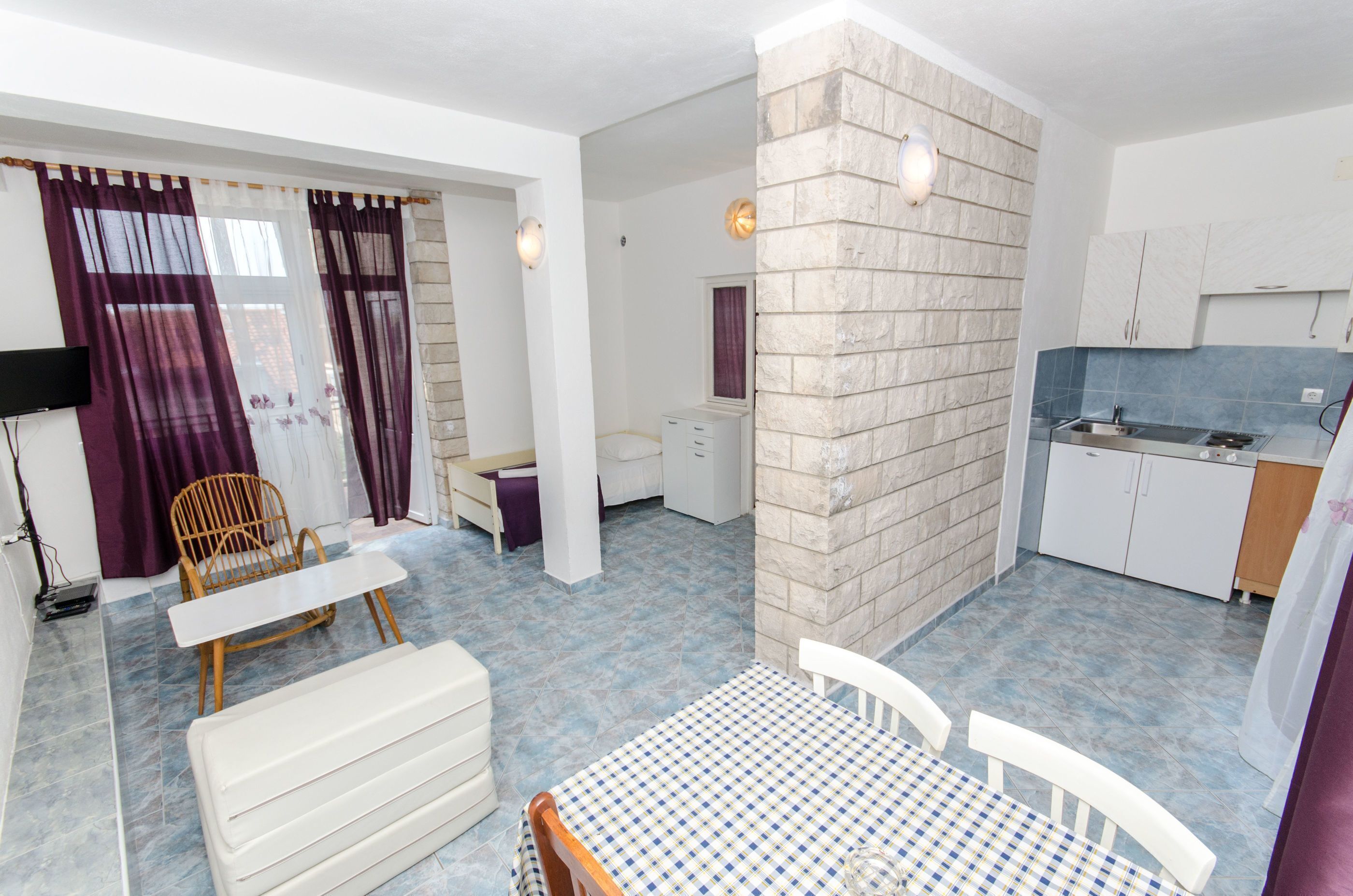 A compact living space with a dining area, a kitchenette, and a small bathroom.