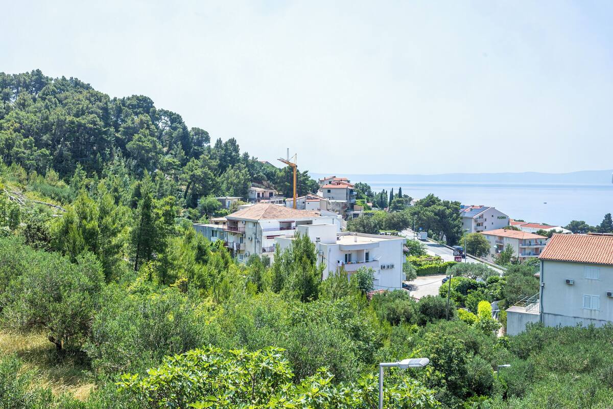 A coastal village with white buildings, a wind turbine, and a view of the sea.