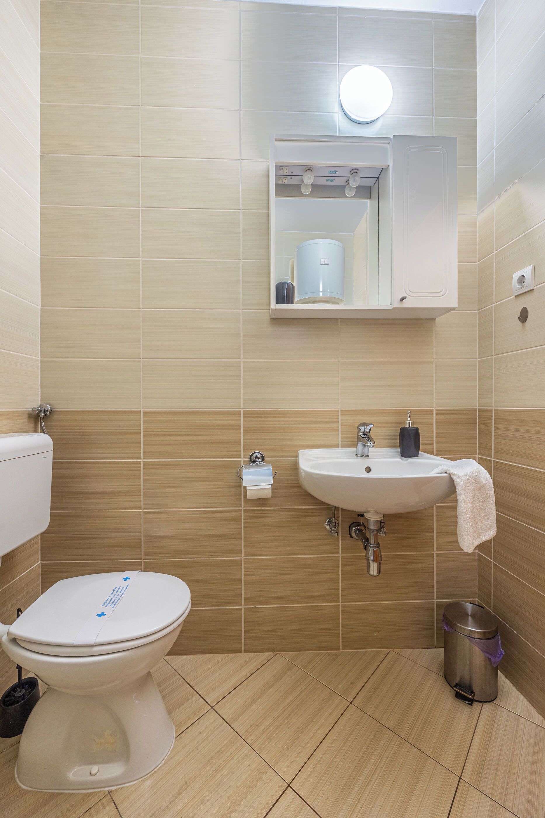Ein Badezimmer mit Toilette, Waschbecken und Spiegel.