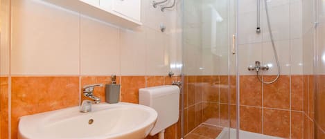 A bathroom with a sink, toilet, and shower.