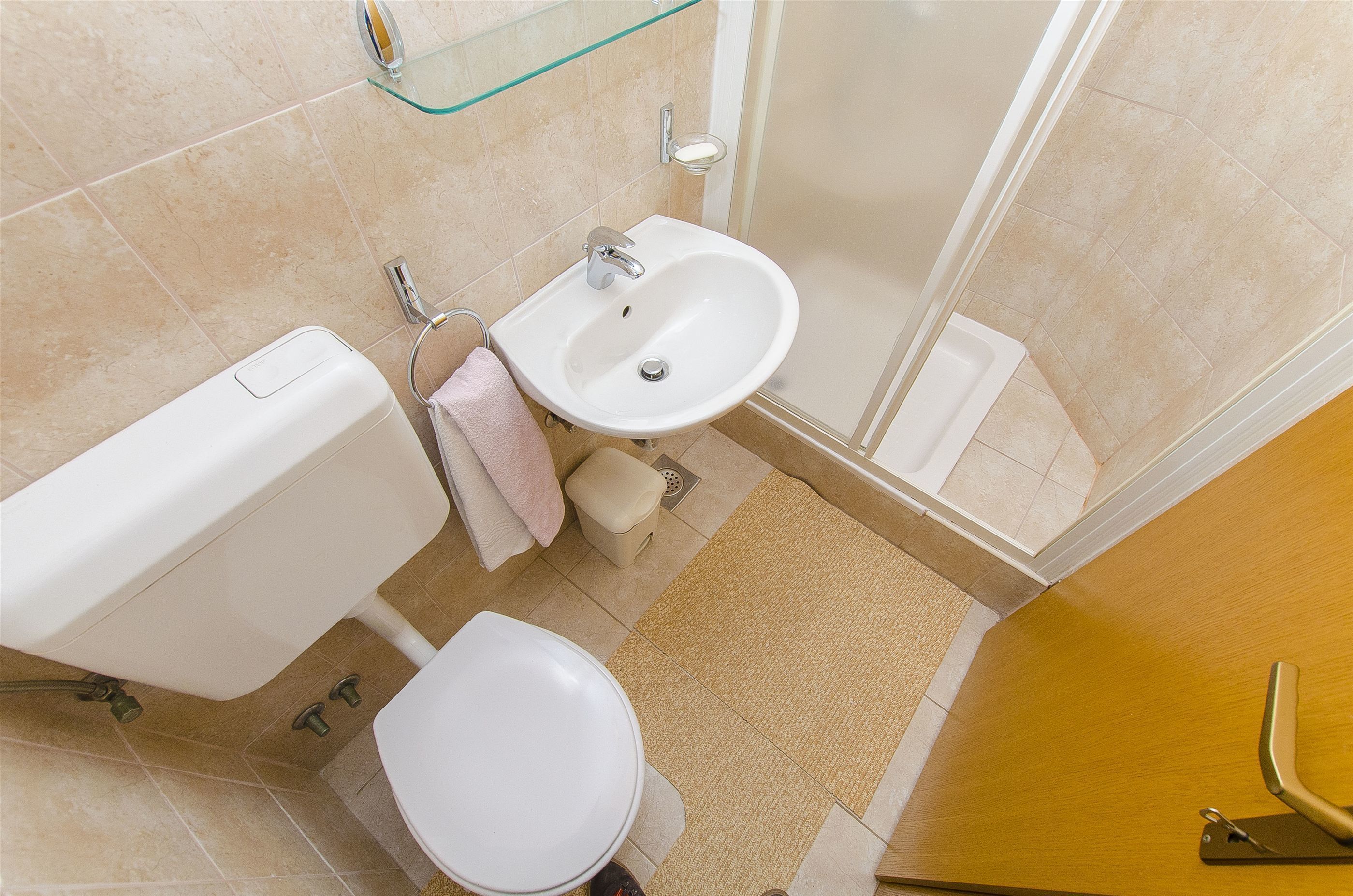 A bathroom with a toilet, sink, and shower.