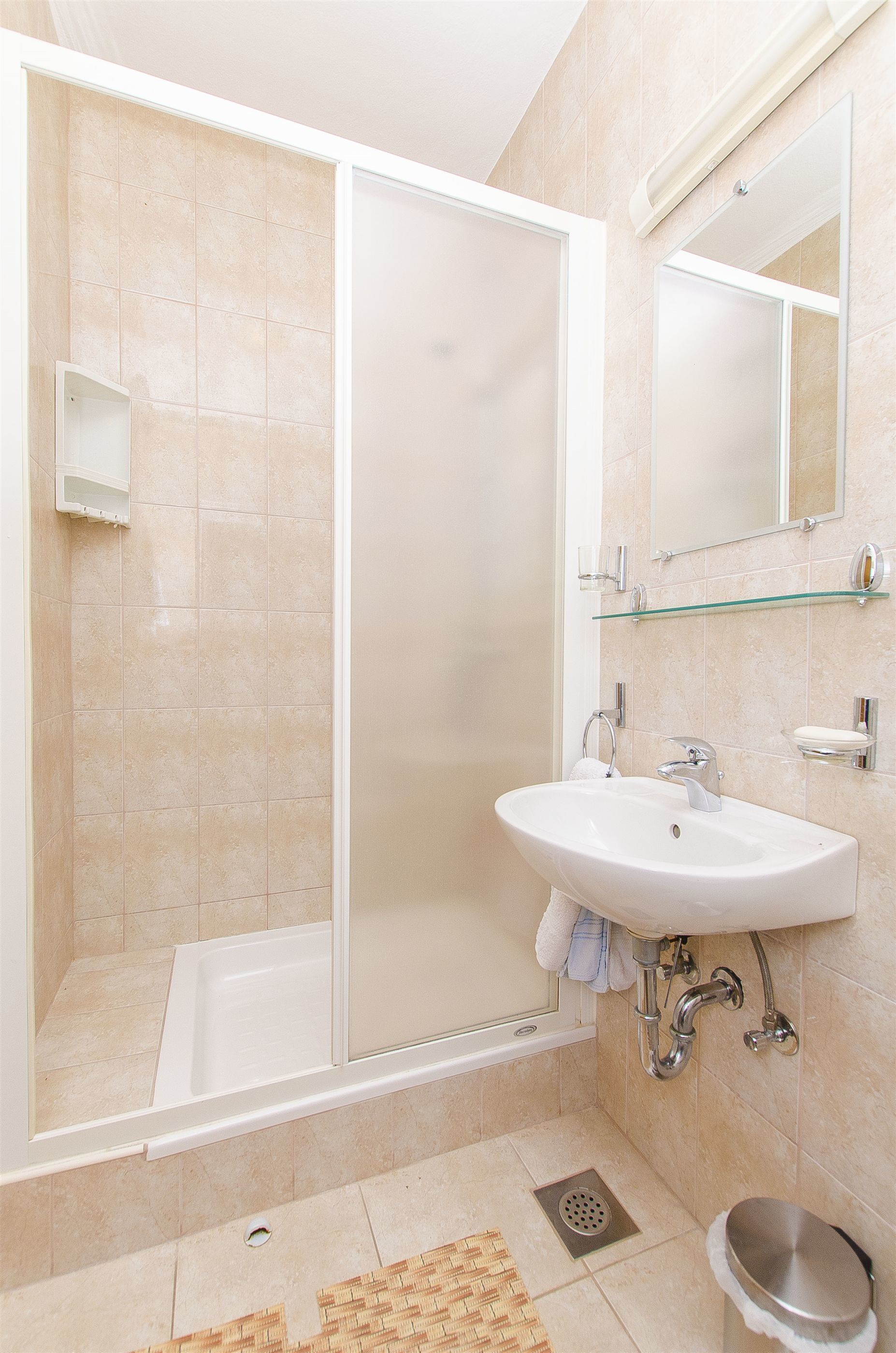 A modern bathroom with a shower, sink, and toilet.
