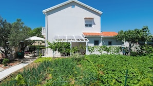 A white building with a red-tiled roof, a small window, and a covered patio area. - Apartment Ivan Vrsi (Vrsi)