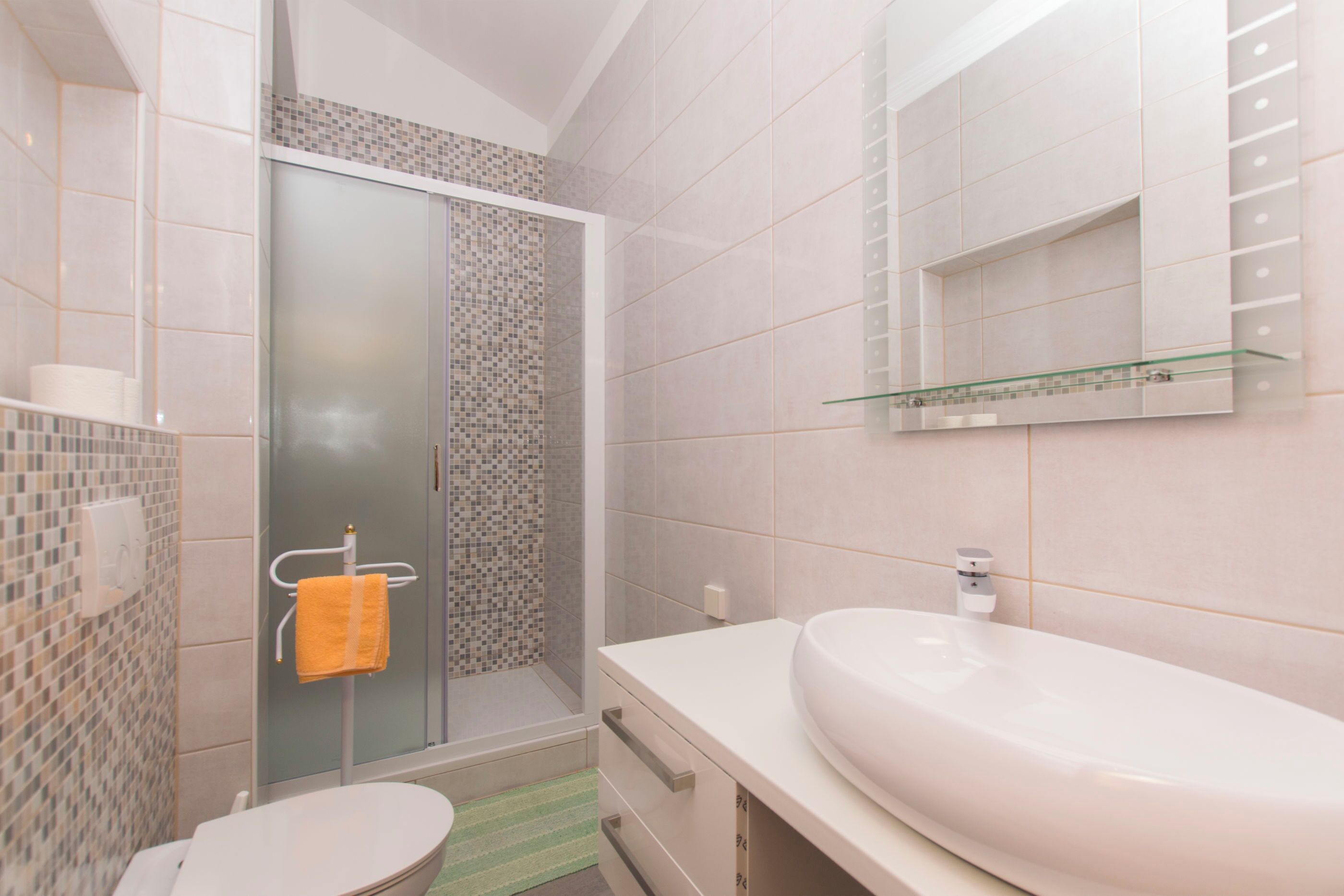 A bathroom with a shower, toilet, and sink.