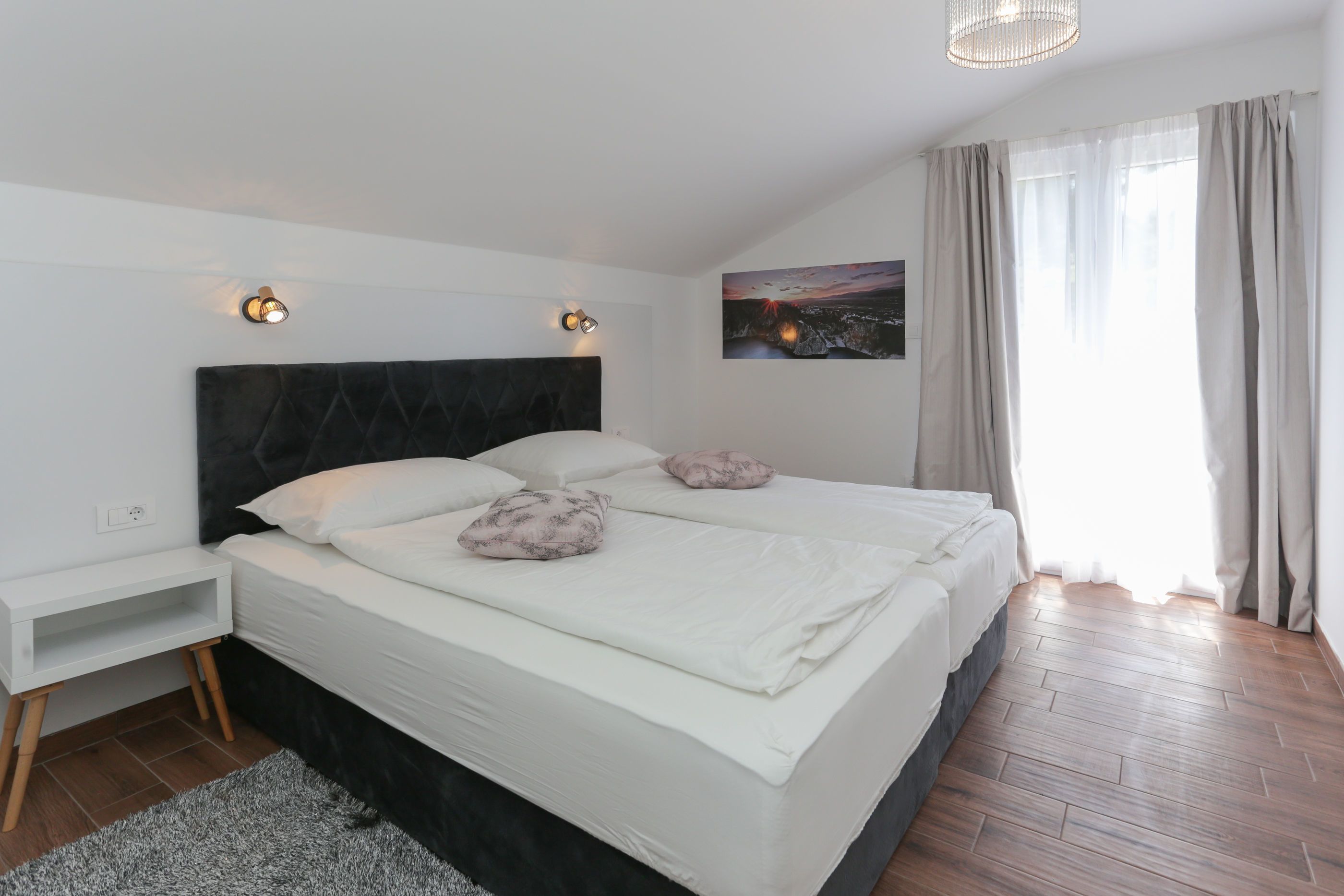 Ein modernes Schlafzimmer mit einem großen Bett, Nachttischen und einem Beistelltisch.