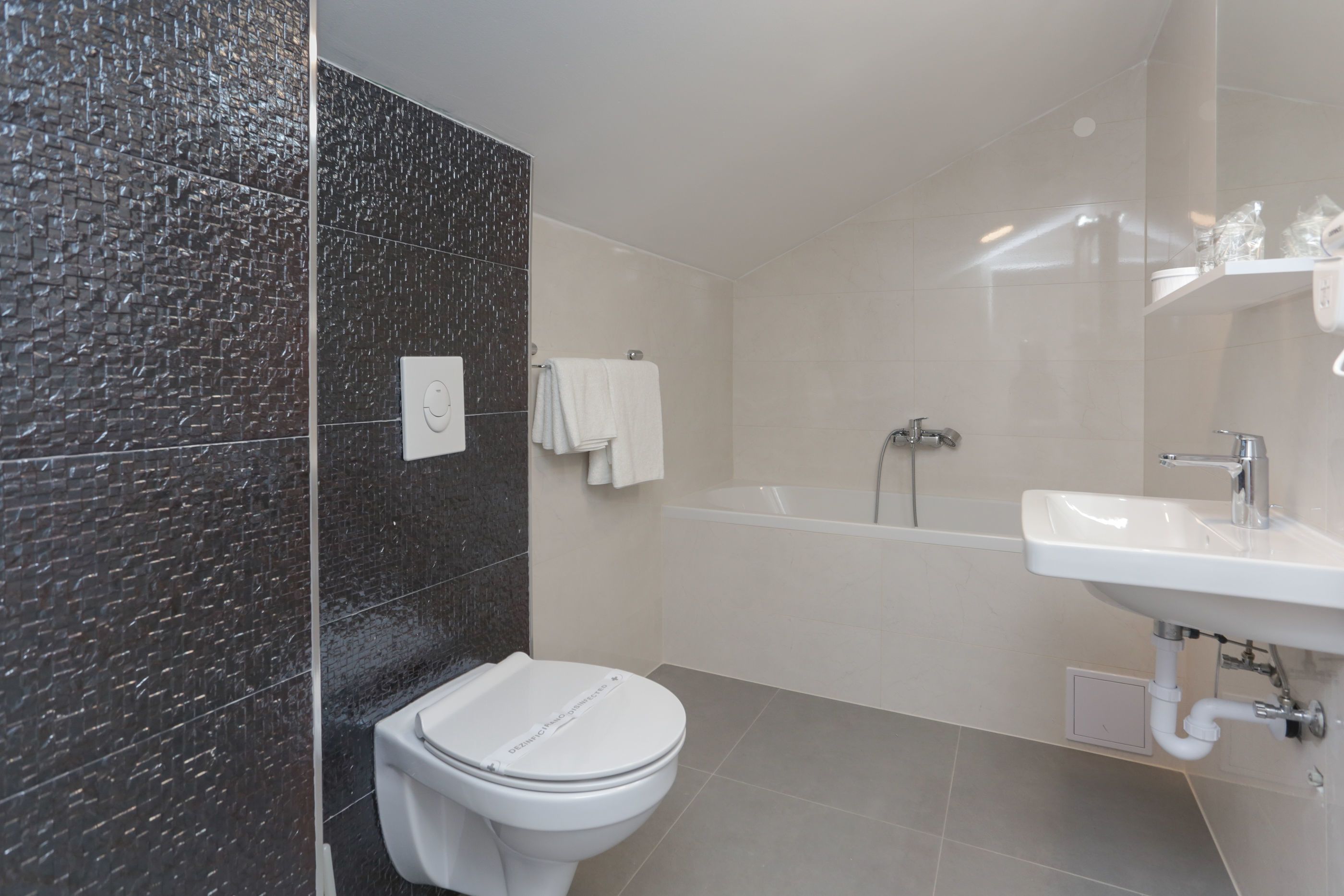 Un baño moderno con inodoro, bañera y lavamanos.