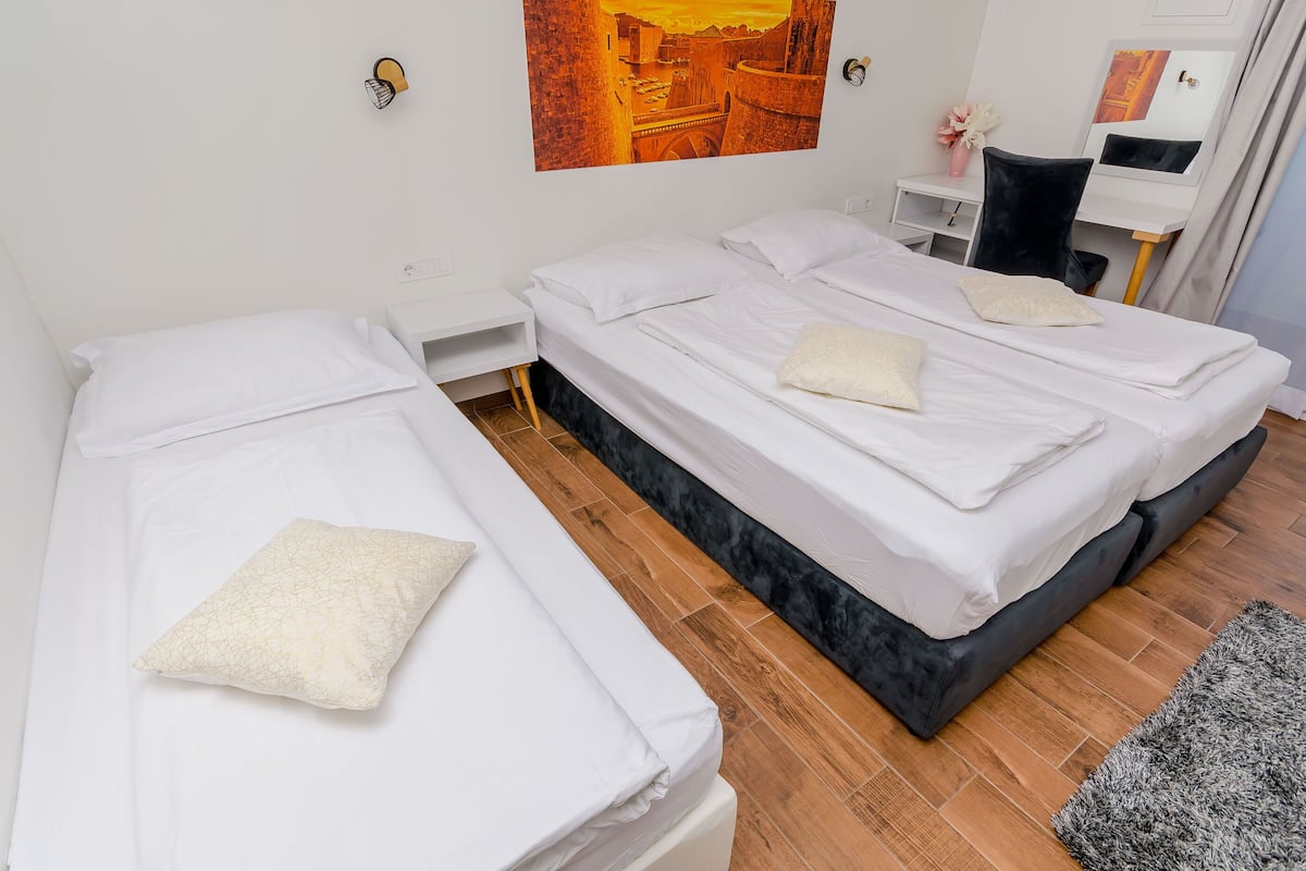 Een hotelkamer met twee eenpersoonsbedden, een bureau en een stoel.