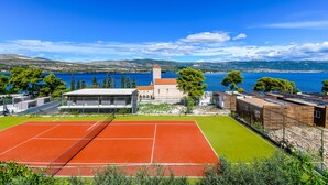 A tennis court with a clear view of the sea and mountains in the background. - Apartments Villa Niko (Arbanija)