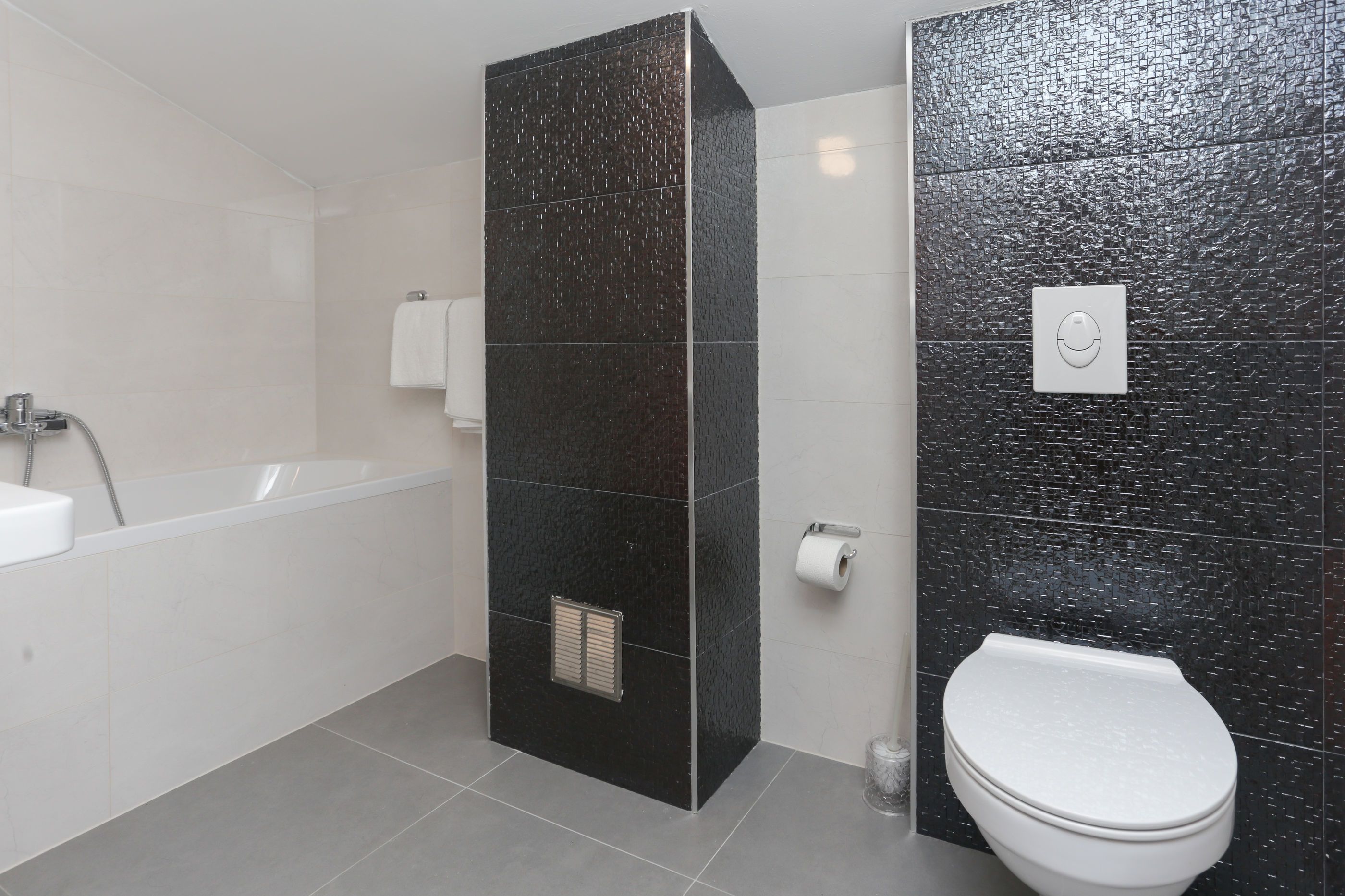 Ein modernes Badezimmer mit Badewanne, Toilette und Duschbereich.