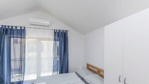 Une chambre à coucher avec un lit, une armoire et une fenêtre avec des rideaux.