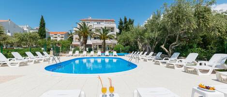 A pool area with lounge chairs and a swimming pool.