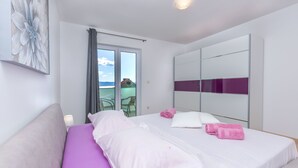 Een moderne hotelkamer met een groot bed, een balkon met uitzicht en een grote spiegel.