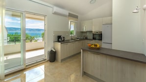 A modern kitchen with a view of the sea, a balcony, and a trash bin. - Apartments Villa Aquamarine (Duce)