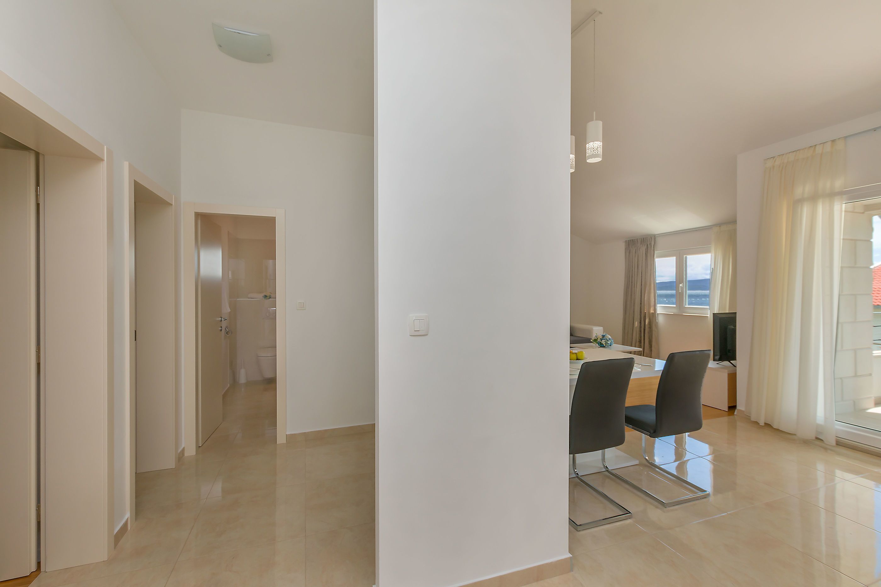 Apartamento moderno com cozinha, área de jantar e vista para o mar.