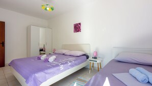 Un dormitorio ordenado con cama, una mesita de noche, un espejo y una decoración en la pared.