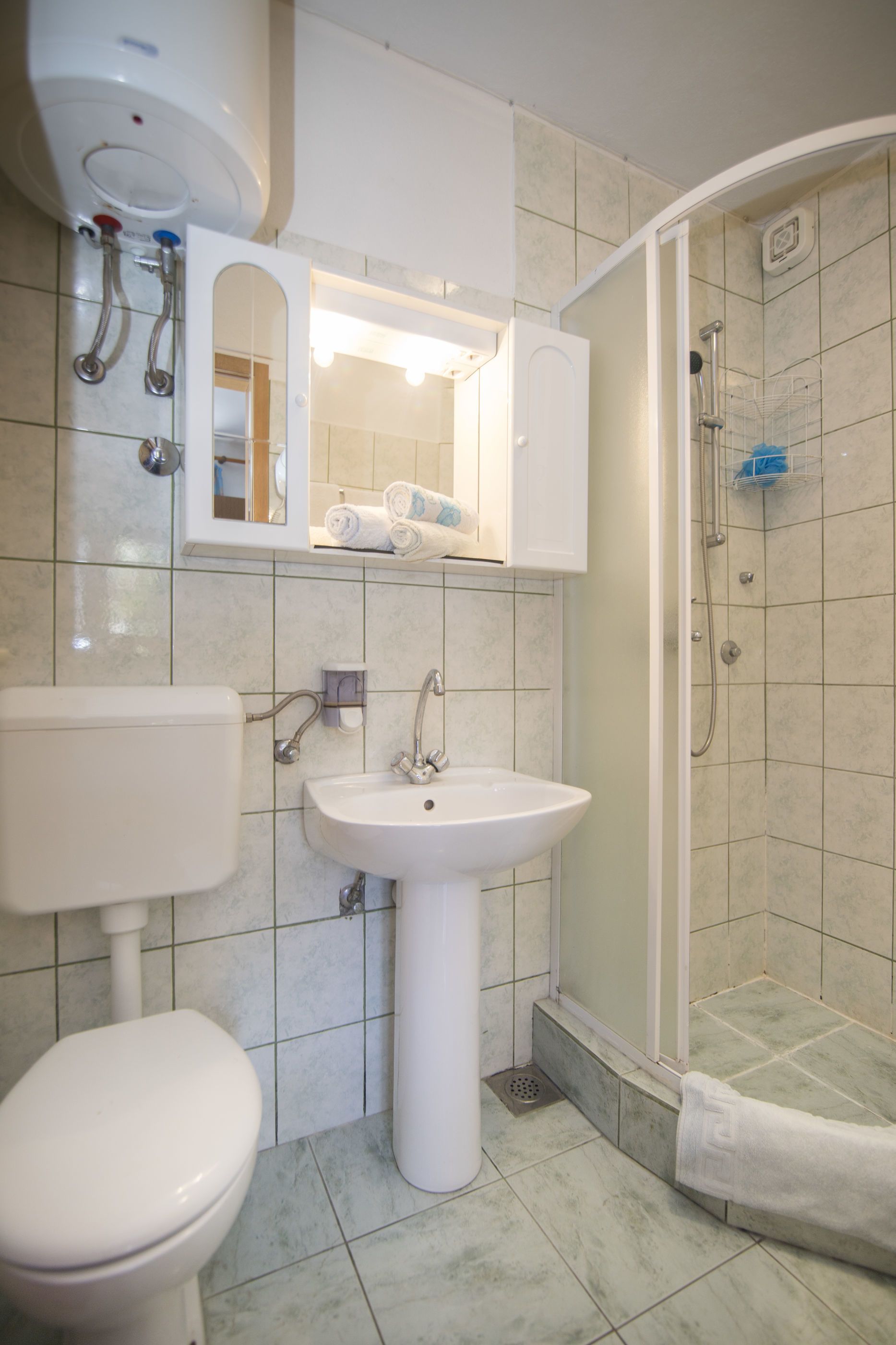 A bathroom with a toilet, sink, and shower.
