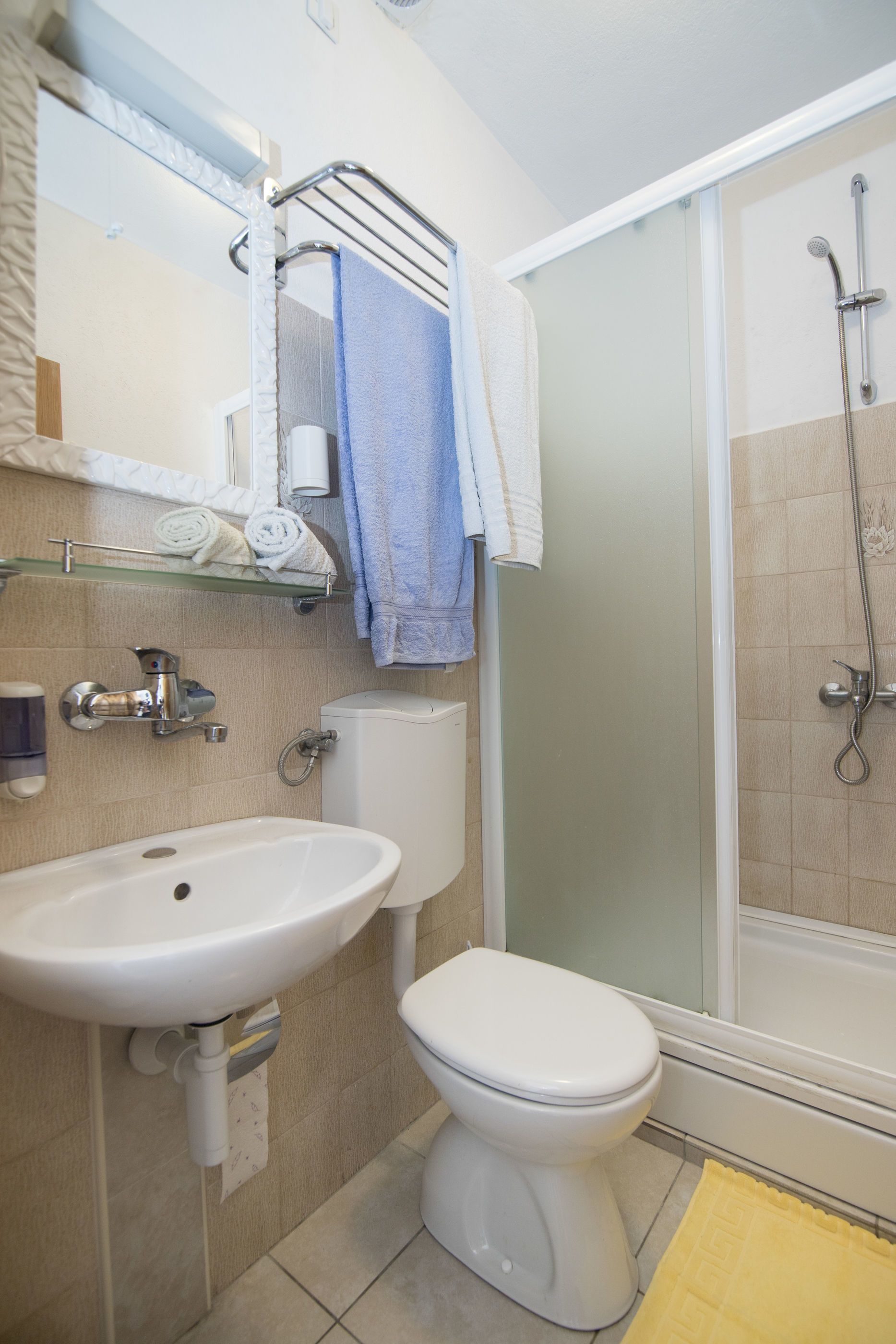 A bathroom with a sink, toilet, and shower.