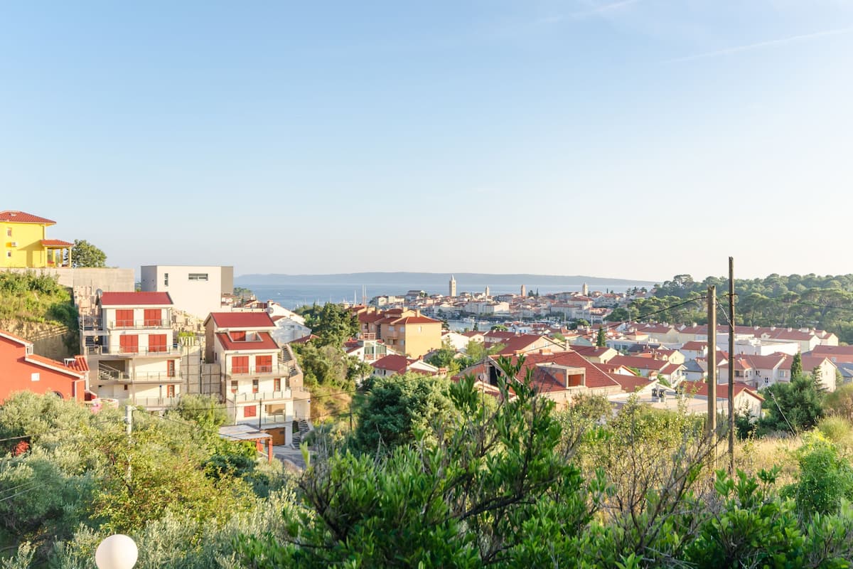 Eine Küstenstadt mit roten Dächern, einer markanten Kirche und Blick aufs Meer.