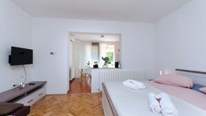 Una habitación de hotel con cama, escritorio, silla y televisor.