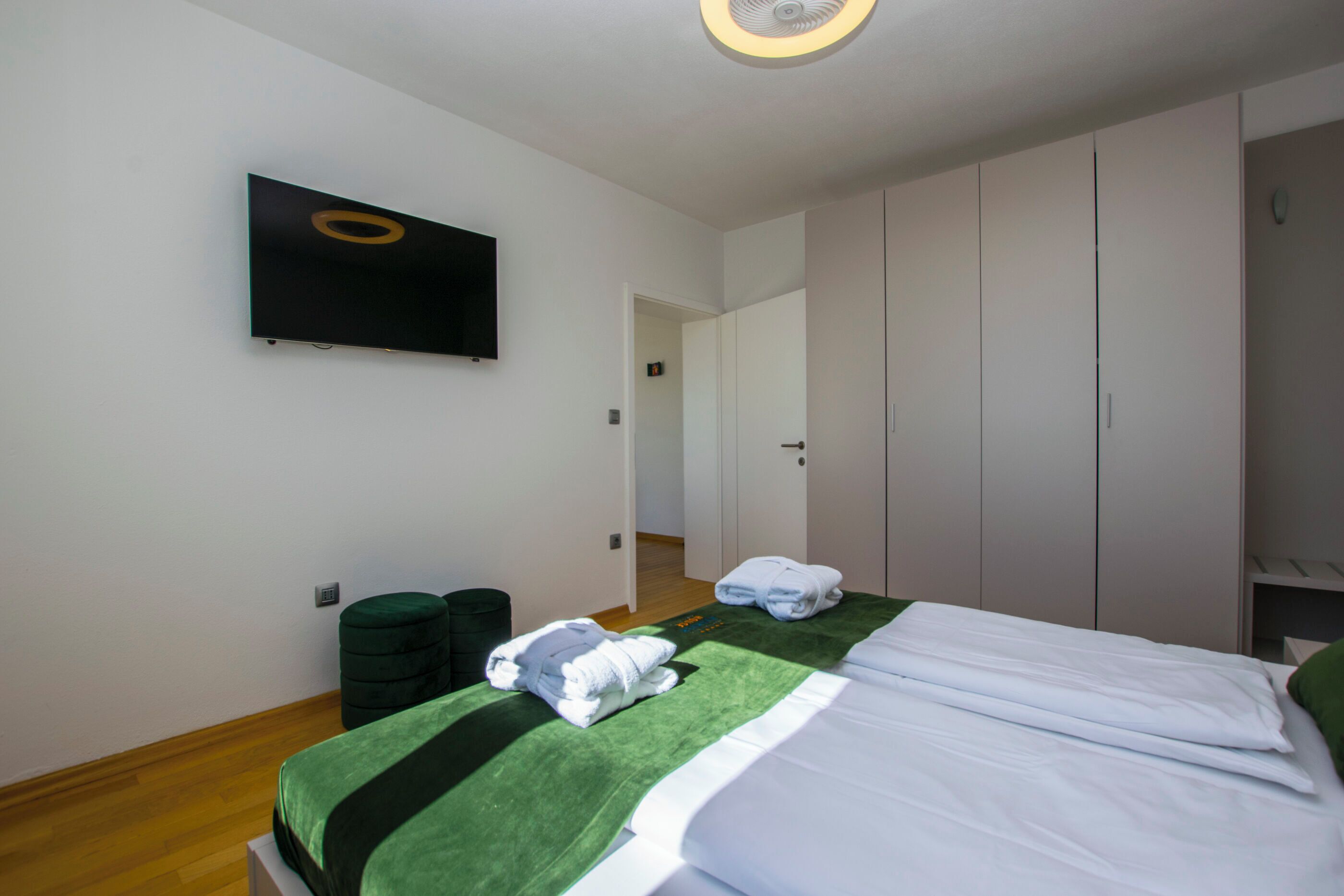 Une chambre d’hôtel équipée d’un lit, d’un téléviseur à écran plat fixé au mur et d’une armoire.