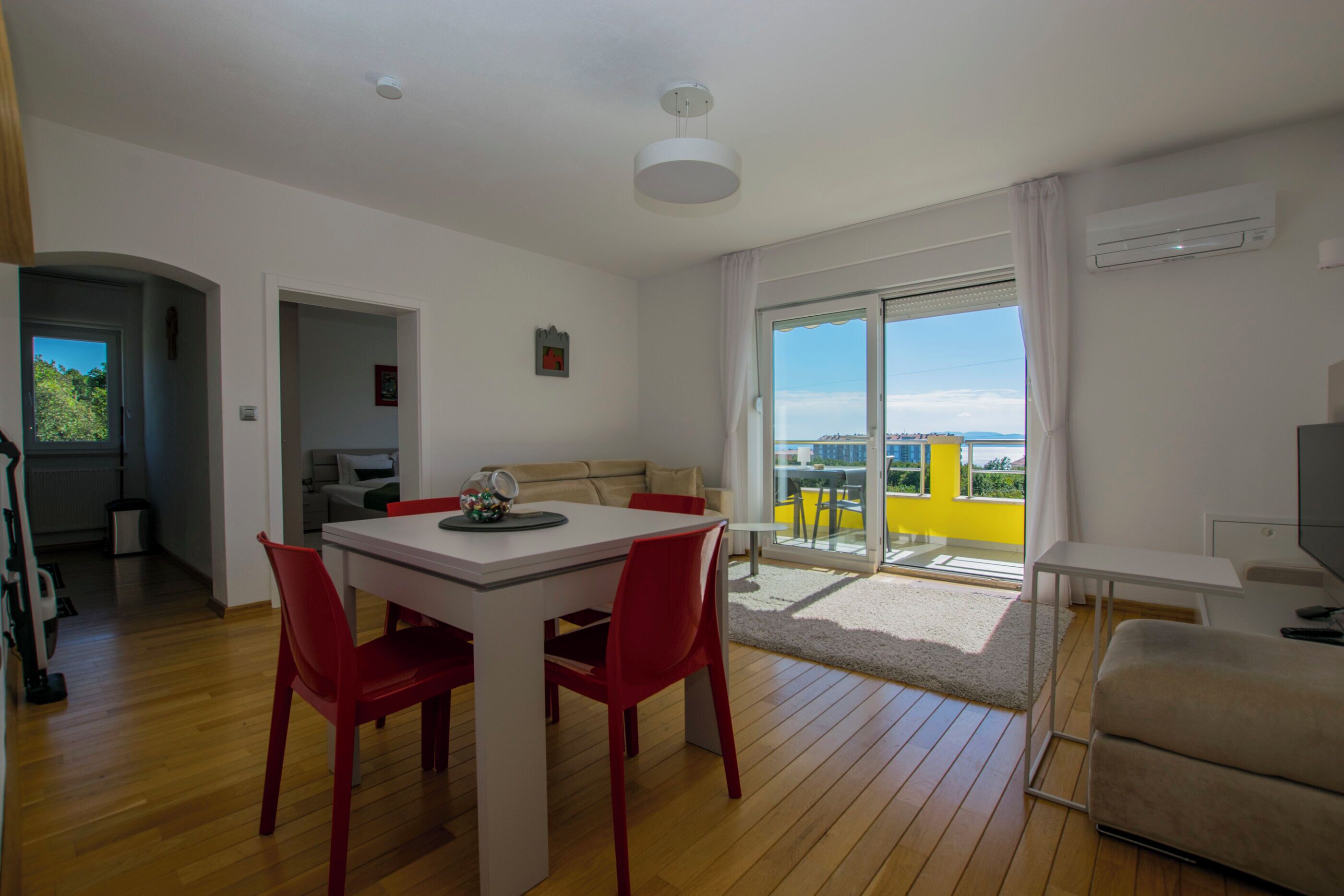 A modern living space with a dining area, a sofa, and a TV.