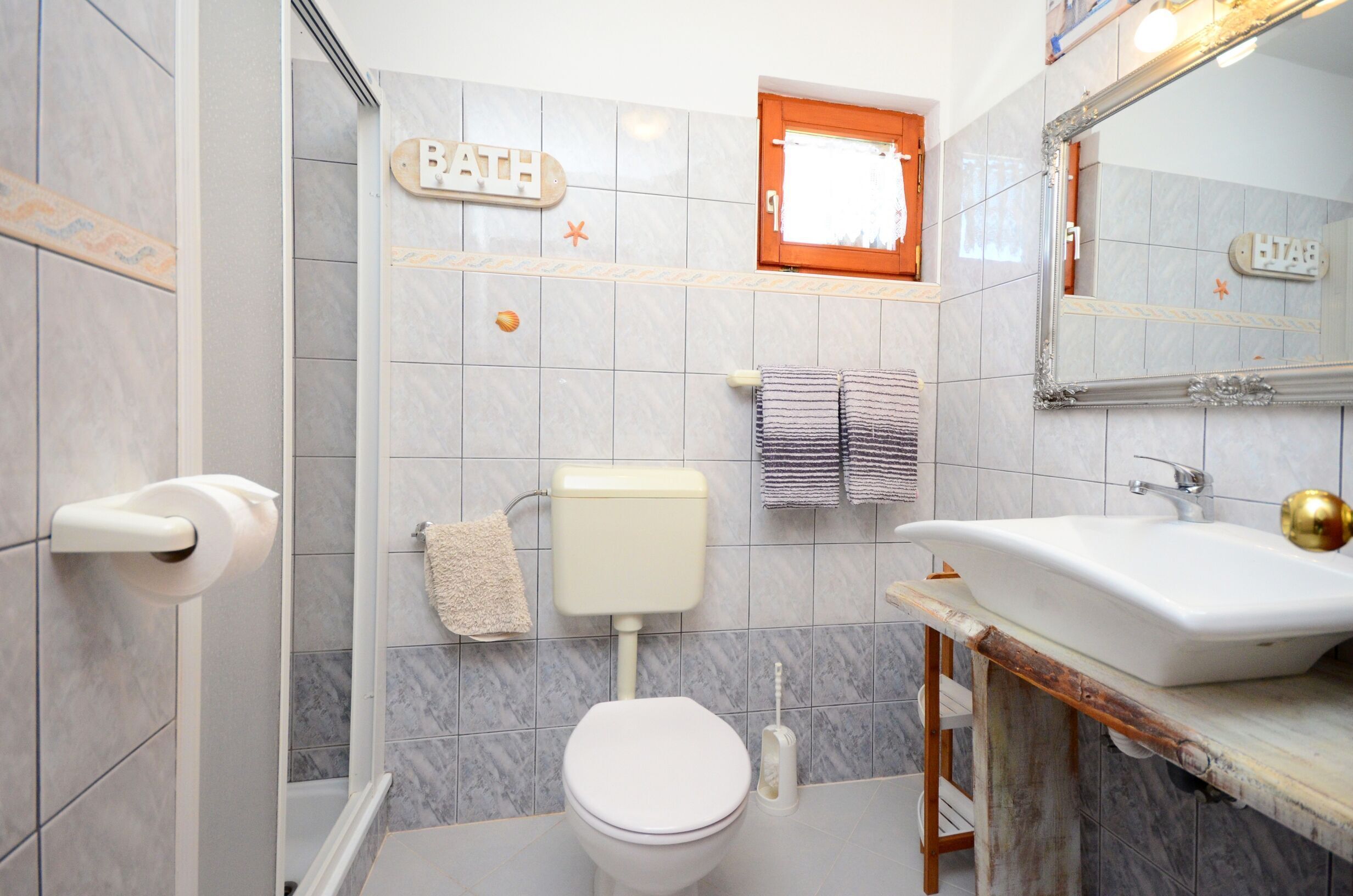 A bathroom with a toilet, sink, and a mirror.