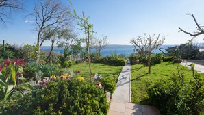Ein Garten mit einem Pfad, der zu einem malerischen Meerblick führt.