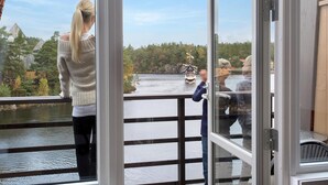 A view from a balcony overlooking a river with boats, surrounded by trees and buildings. - Dyreparken Safarihotell (Kristiansand)