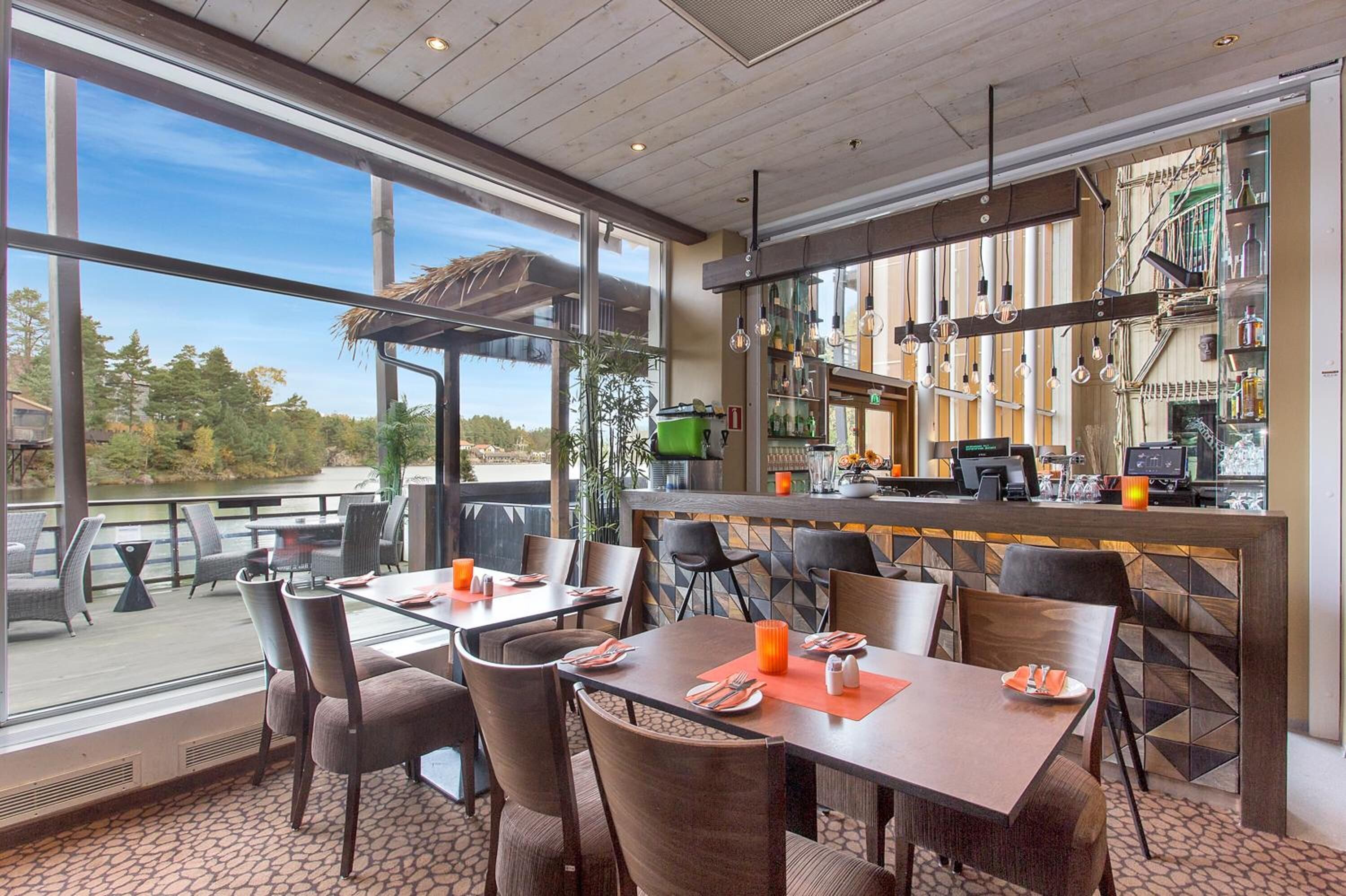 Ein Restaurant mit Außenbereich, einer Bar und Seeblick.