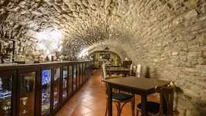 Interior de paredes de piedra con una zona de bar y asientos.