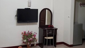 A living room with a television, a desk with a mirror, a chair, and a sofa. - Leisure Homestay (Hualien City)