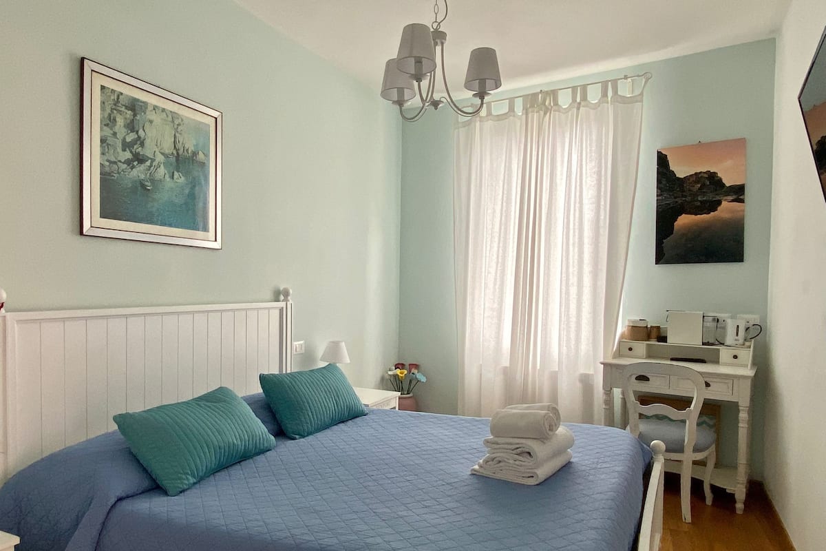 Un dormitorio con cama, escritorio y silla.