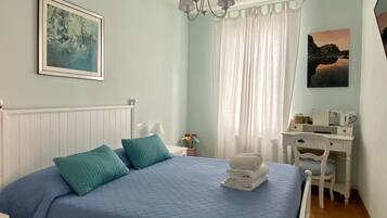 Quarto com cama, escrivaninha e cadeira.