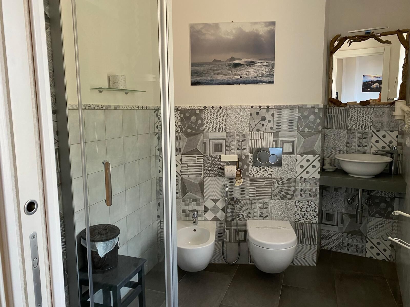 A modern bathroom with a shower, bidet, and sink.