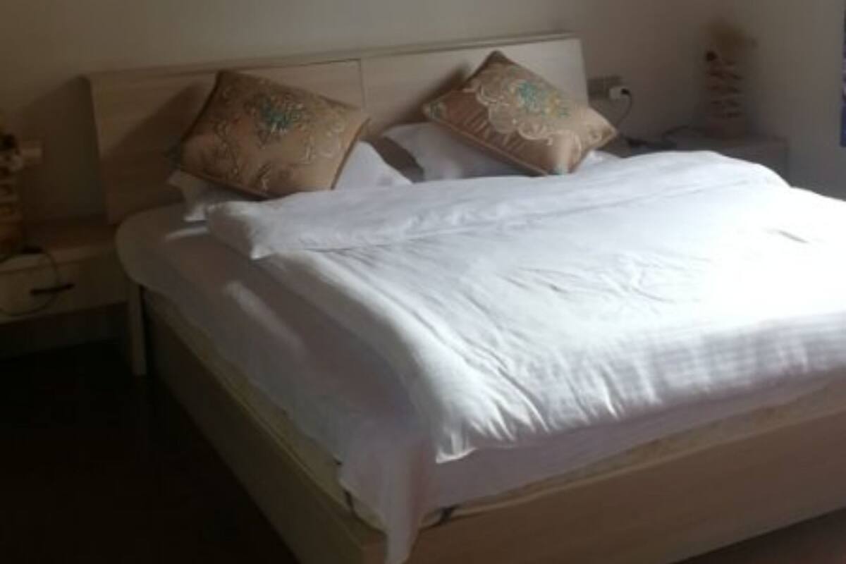 A bedroom with a wooden ceiling, a bed with white bedding, and two nightstands.