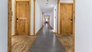 A long hallway with wooden doors on either side, leading to a room at the end. - Floral Hotel Qingshe Chengdu (Chengdu)