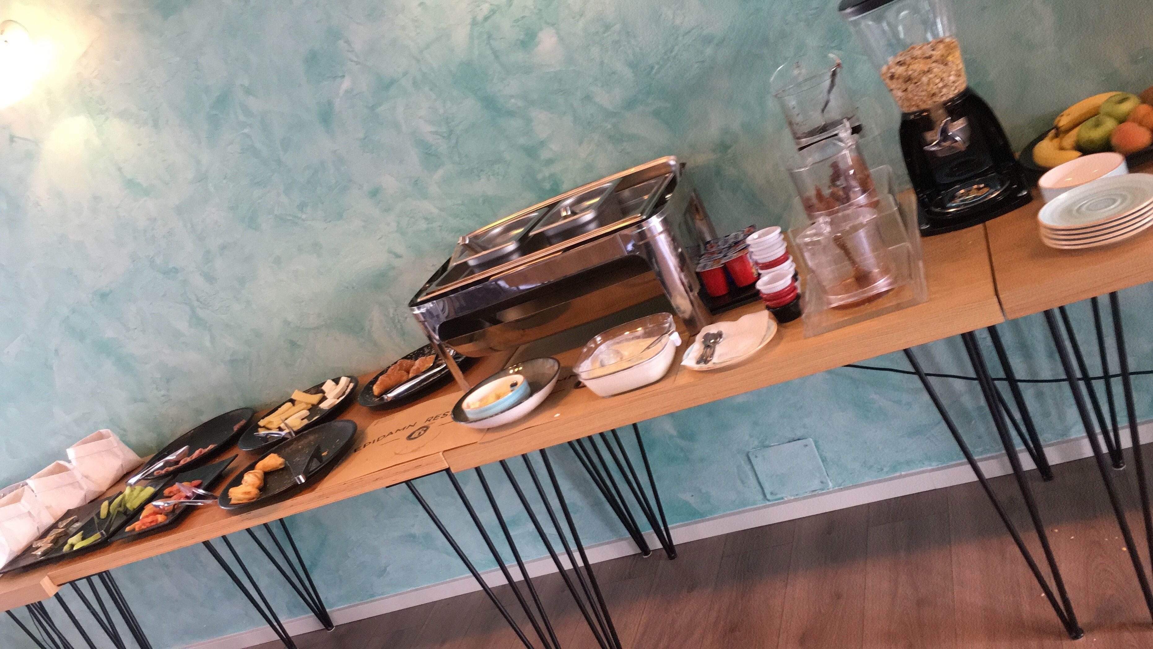 Uma mesa de buffet com diversos alimentos e utensílios.