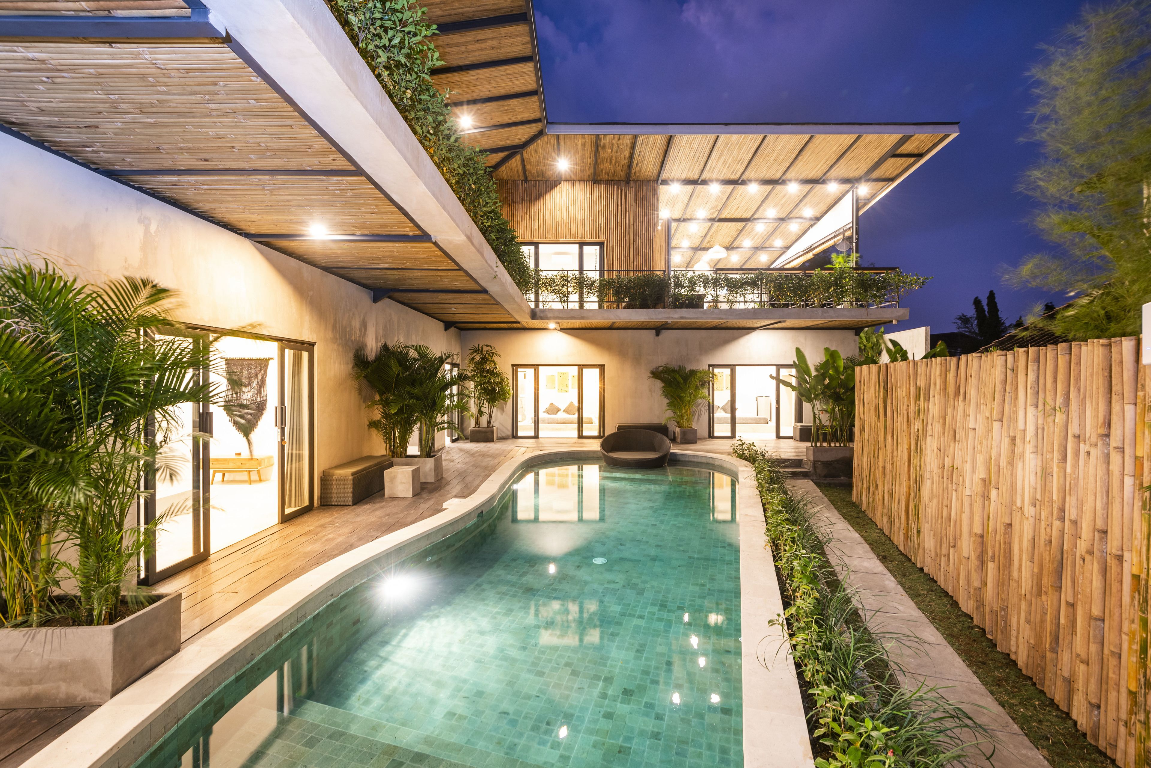 Una casa moderna con piscina, terrazza in legno e area relax all'aperto.