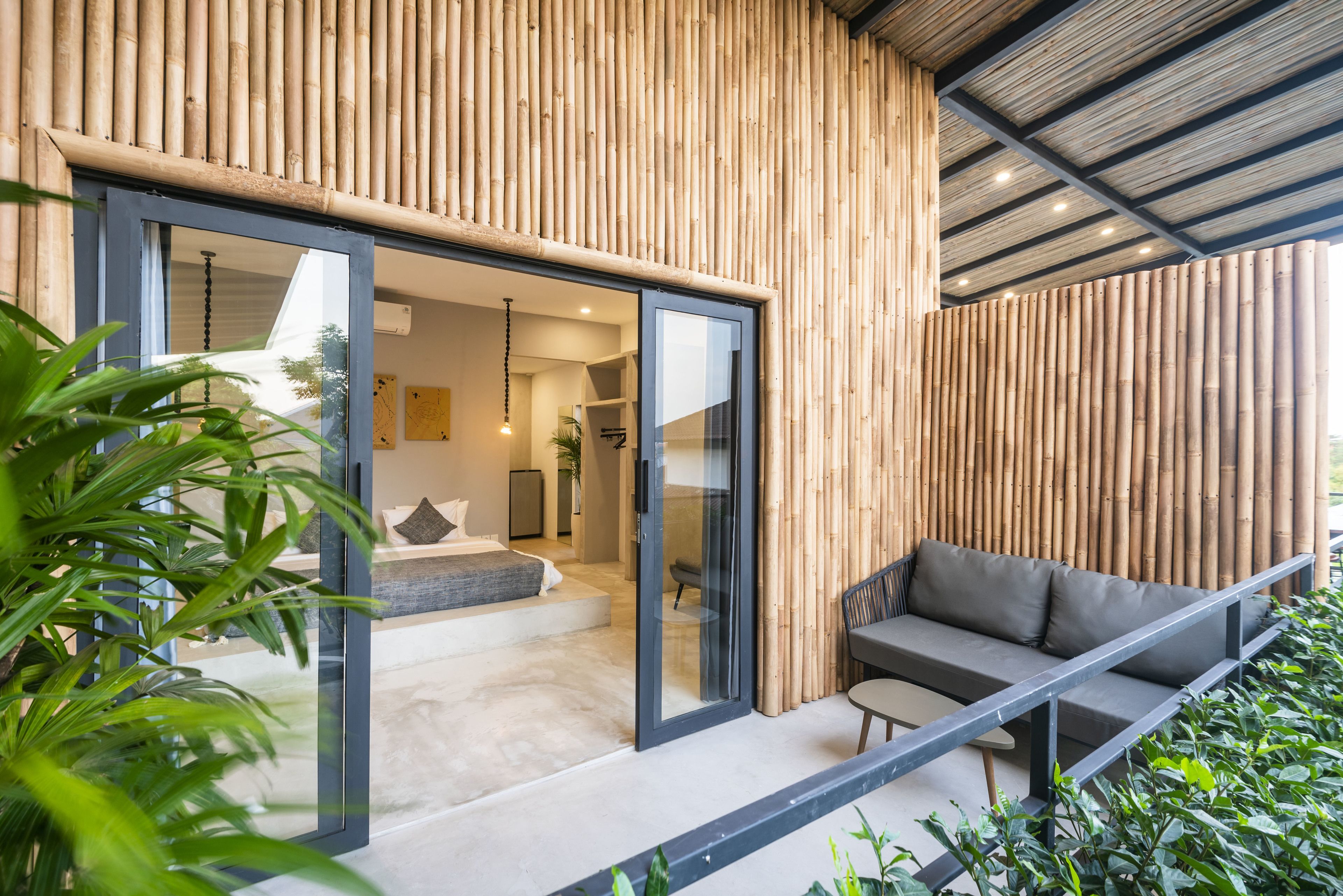 A modern interior with a sliding glass door leading to a living area with a sofa and a small table.