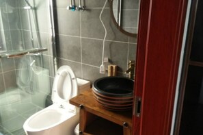 A bathroom with a toilet, a sink, and a shower.