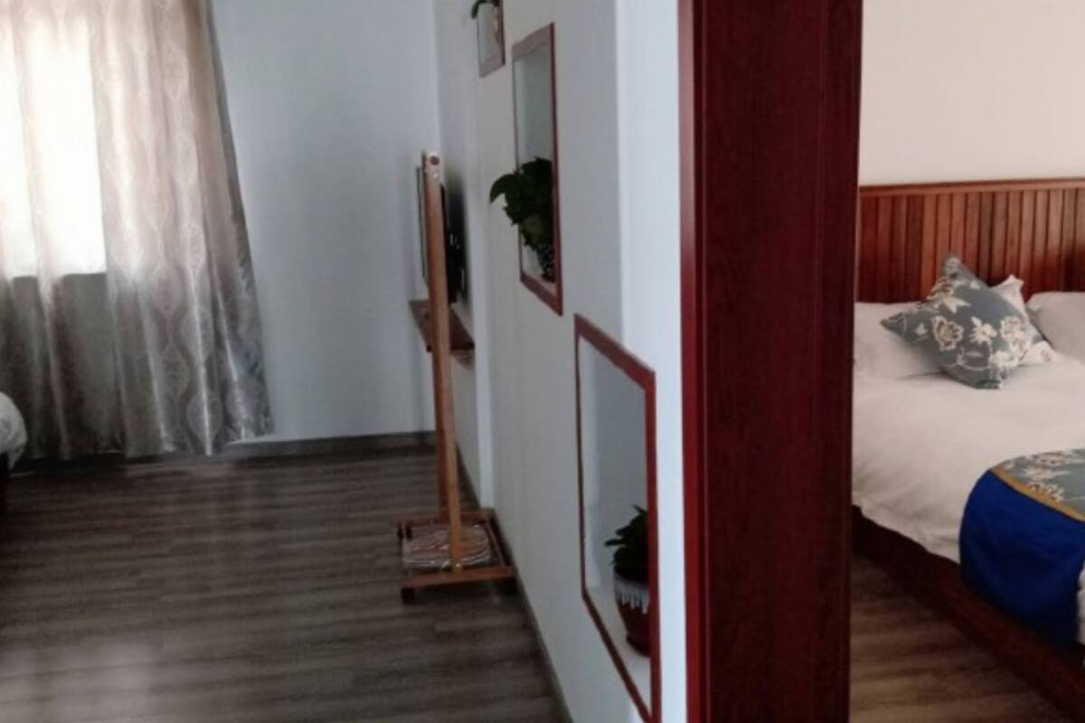 A hotel room with a bed, a wooden headboard, a bedside table, and a mirror.
