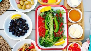 A variety of food items arranged on a table, including olives, tomatoes, cucumbers, and other vegetables. - Alacati Sardunya Hotel (Cesme)