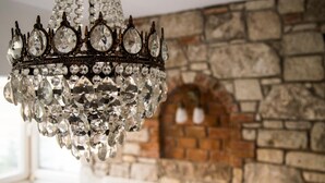 A chandelier with multiple crystal elements hanging from a metal frame. - Alacati Sardunya Hotel (Cesme)