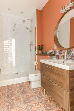 A bathroom with a shower, toilet, and vanity with a mirror. - Bright Two BR Period Apartment in Whitechapel (London)