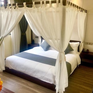 A bed with a canopy, a bedside table, and a nightstand.