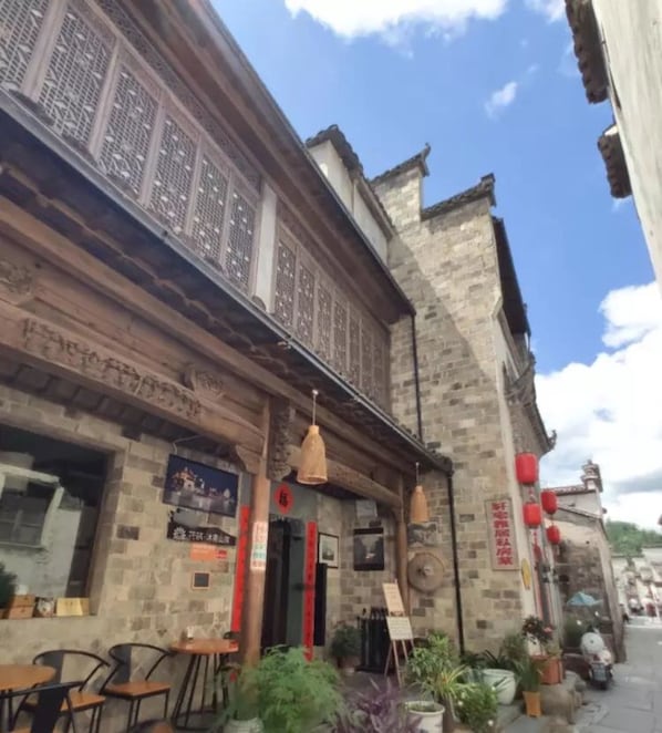 A traditional building with a stone facade, wooden beams, and a signboard.