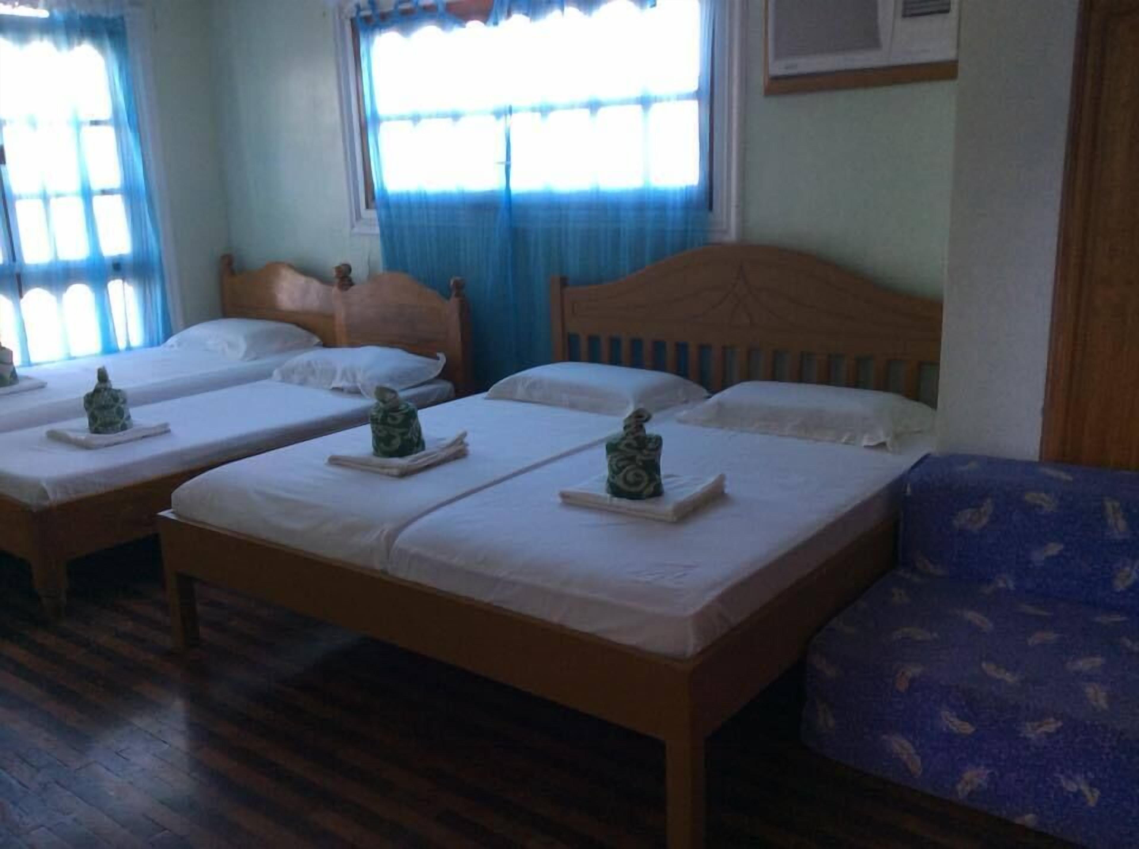 Una habitación con tres camas de madera, cada una con un cojín y un pequeño adorno.