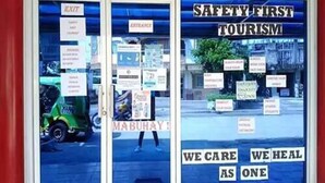 A building entrance with signs reading "Safety First Tourism" and "We Care We Heal As One". - Surigao Tourist Inn Main (Surigao)