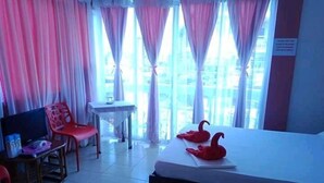 A hotel room with a bed, a TV, a desk, and a chair. - Surigao Tourist Inn Main (Surigao)